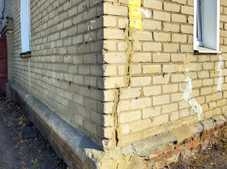 Vertical crack in the wall at the corner of a brick house