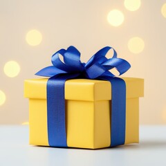 Yellow gift box with blue ribbon and bow for celebrations birthdays anniversaries and special occasions