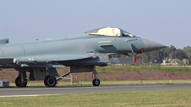 military fighter jet from air force parked airbase covered up waiting for missions combat operational close panning shot closeup operations aviation aircraft 