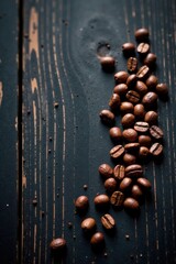 Dark roasted coffee beans scattered on a rustic wooden surface