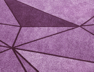 Close up of carpet rug flooring in magenta and purple color. Star geometric pattern, triangle and...