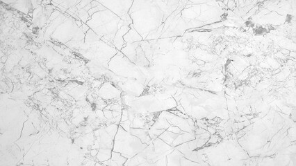 A white marble wall with cracks and holes. The wall is smooth and shiny, but the cracks and holes give it a rough and aged appearance. The contrast between the smooth surface