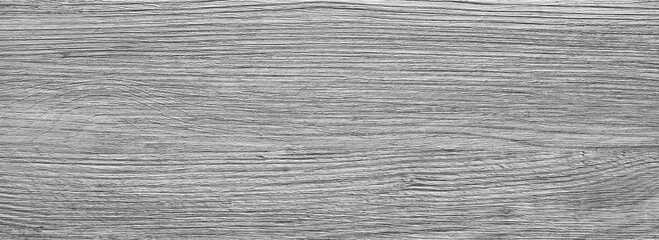 Obraz premium A wooden surface with a grainy texture. The wood is grey and has a rough appearance. The surface is not smooth and has a lot of texture