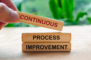 Continuous process improvement text on wooden blocks. Business strategy and improvement concept