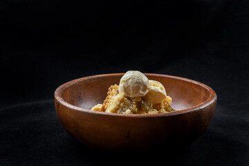 A classic spiced dessert encased in a buttery, flaky crust. Warm and cozy, with a scoop of vanilla ice cream. Side view