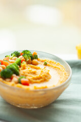 Creamy hummus topped with chopped broccoli, carrots, and chickpeas. Healthy and delicious Mediterranean-style dip.