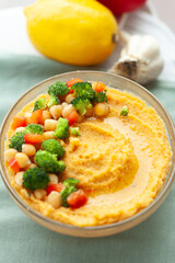 Creamy hummus topped with chickpeas, broccoli florets, and diced bell peppers. A healthy and flavorful vegetarian dip.