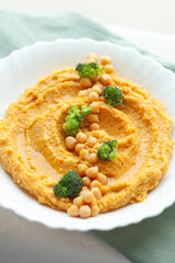 Creamy hummus topped with chickpeas and broccoli florets. A healthy and delicious Mediterranean-inspired dish.