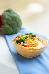 Delicious hummus topped with chickpeas and broccoli florets. Healthy and flavorful snack or appetizer.