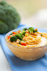 Delicious hummus topped with chickpeas, broccoli, and bell peppers.