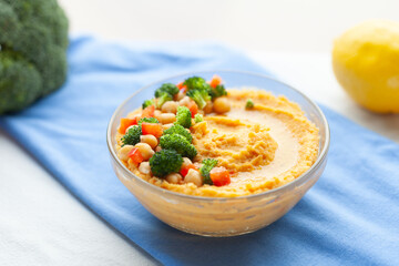 Delicious hummus topped with chickpeas, broccoli, and bell peppers.