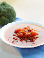 A bowl of vibrant tomato soup, garnished with fresh tomato chunks. A healthy and delicious meal.