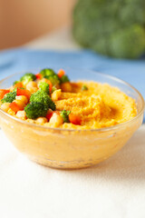 Creamy hummus topped with chickpeas, broccoli, and carrots.