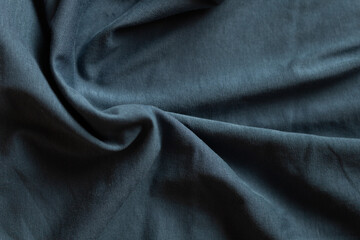 Close-up of textured dark teal fabric, showing folds and wrinkles.  Soft, draping material ideal for apparel or design projects.