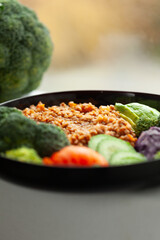 Healthy buckwheat bowl with broccoli, avocado, cucumber, and tomato.