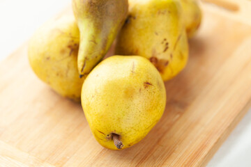Ripe pears on a wooden cutting board, ready for use in a delicious recipe.  Perfect for baking or enjoying fresh.