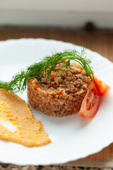 Hearty buckwheat porridge with vegetable garnish, served with a side of creamy puree. A simple, healthy, and delicious meal.