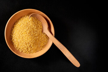 Cereal. Bulgur in a wooden spoon and plate