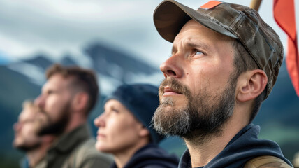 small group of activists stands determined in remote mountainous location, holding flag and looking forward with focus and resolve