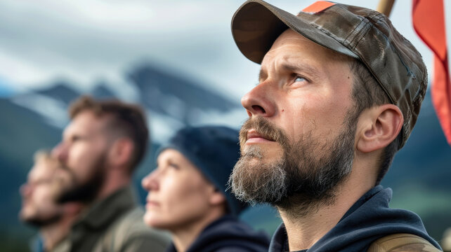 small group of activists stands determined in remote mountainous location, holding flag and looking forward with focus and resolve