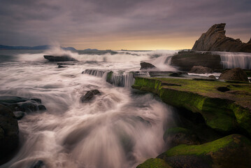 Obraz premium The waves enter with force between the rocks of the coast of the Cantabrian Sea on Azkorri beach in Getxo, Bizkaia