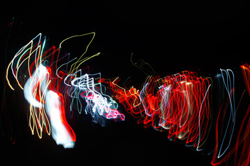 Abstract blurred colorful light effect on a black background. Long exposure photo of moving camera.