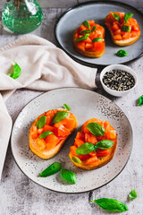 Italian sandwiches with tomatoes, basil and garlic on a plate on a table vertical view