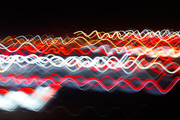 Abstract blurred colorful light effect on a black background. Long exposure photo of moving camera.