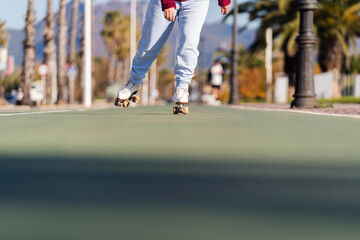 Close up of a senior woman's legs rollerskating on a sunny day, promoting healthy habits and active...