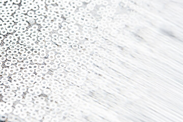 Abstract festive fabric texture with silver sequins.