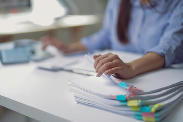 Office worker managing paperwork and using tablet at desk