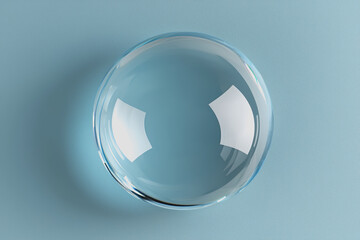 Glass sphere placed on a smooth surface with a vibrant blue background creating a modern and minimalist aesthetic for design and artistic compositions