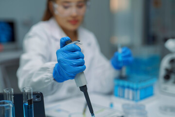 Scientist using micropipette for analysis in laboratory