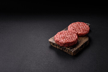 Fresh raw ground beef burger patty with salt and spices