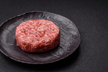 Fresh raw ground beef burger patty with salt and spices