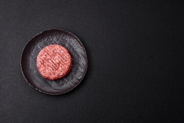 Fresh raw ground beef burger patty with salt and spices