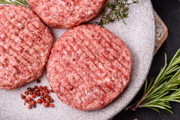 Fresh raw ground beef burger patty with salt and spices