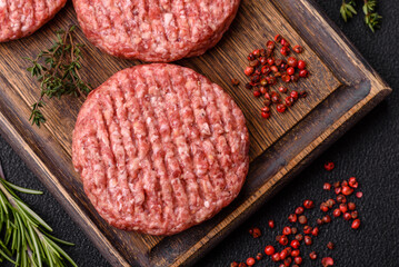 Fresh raw ground beef burger patty with salt and spices