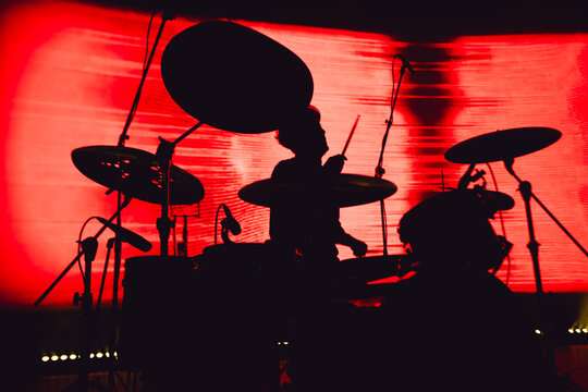 Rock concert poster. A drummer plays drums during a show. Band silhouette on stage.