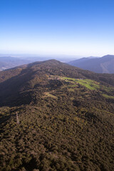 Obraz premium Beautiful scenic view from the top of a mountain seeing the beautiful skyline of green mountains in Girona, Catalonia