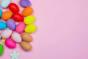 Easter pink background with bright colored eggs and space for text