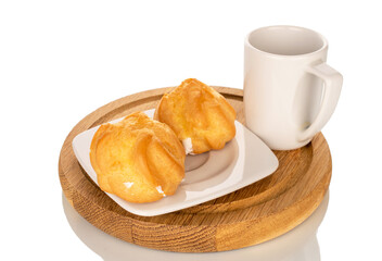 Ceramic cup with eclair on a saucer on a wooden tray, close-up, isolated on a white background.