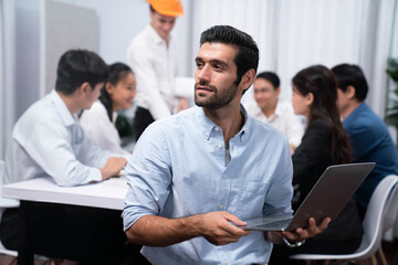 Fototapeta premium Engineer team leader portrait with diverse group of civil engineer and client working together on architectural project, reviewing construction plan and building blueprint at meeting table. Prudent