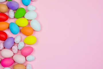 Easter pink background with bright colored eggs and space for text