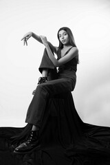 a tall slim caucasian female model with black hair wearing a black suit posing for a model shoot