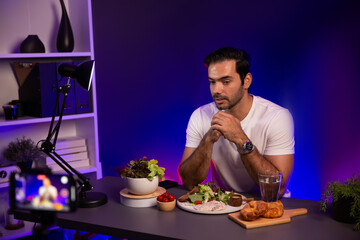 Healthy influencer in host channel presenting fresh vegetables in special dish of salad with brest...