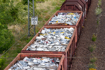 Above view of railway cargo train wagon filled by old rusty black metal scrap garbage forfactory...