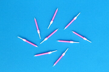 There are pink cake candles on a blue background.	