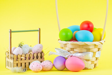 Banner for the Easter holiday. Colored eggs in a basket on a bright background