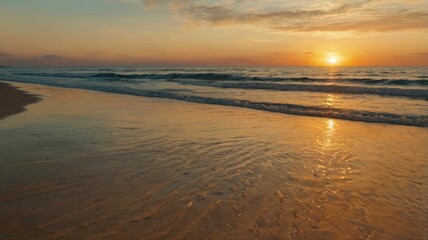 Fototapeta premium A serene sunset over the ocean, reflecting warm colors on the water.